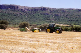 Tractor con empacadora recogiendo paja
